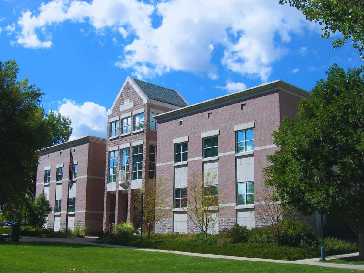 Commercial building with brick exterior and multiple windows in a sunny setting.