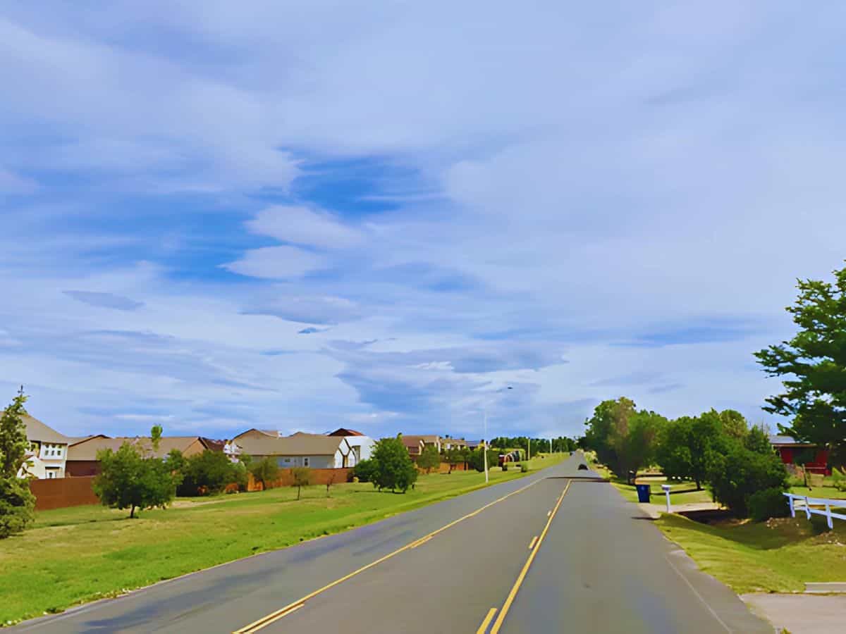 Quiet suburban street with houses and trees in El Paso County, CO.
