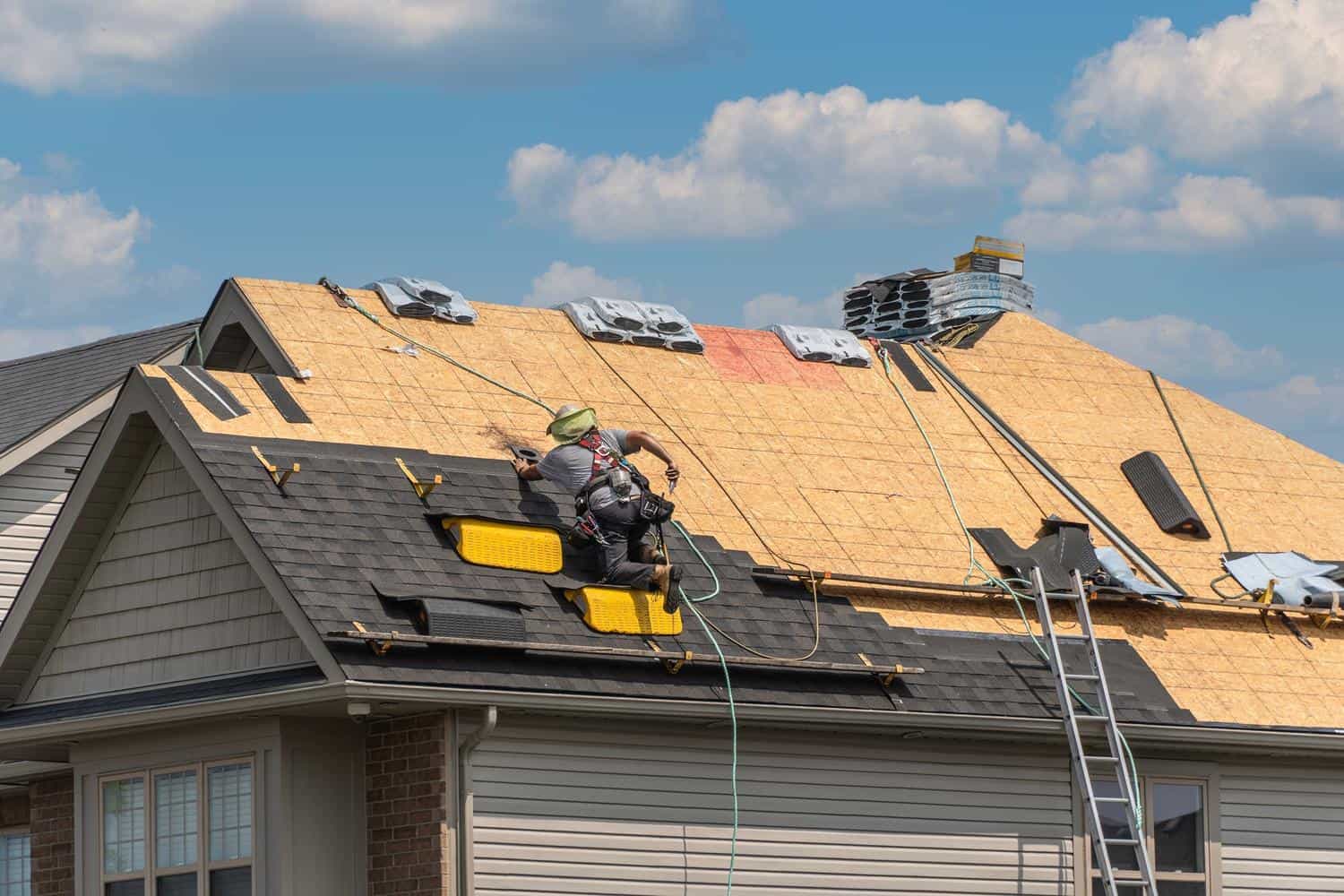 Roofing contractor installing new shingles on a house in Castle Rock, CO.