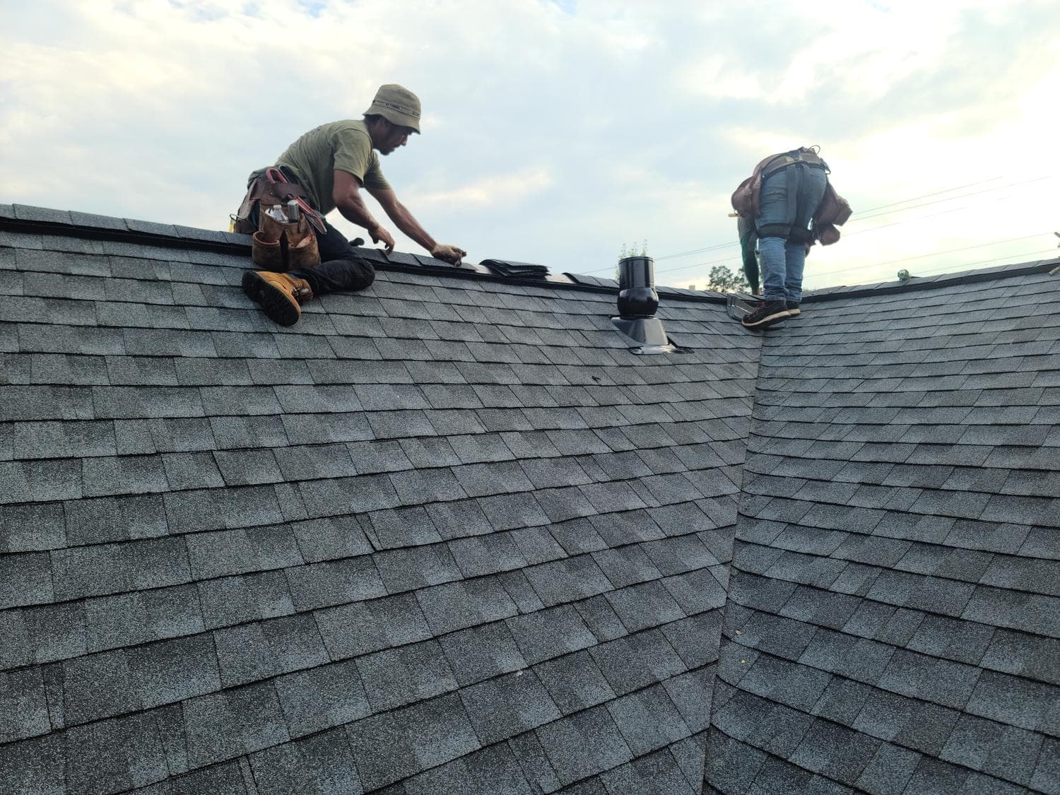 Roofers installing shingles on a residential roof in Lone Tree, Colorado.