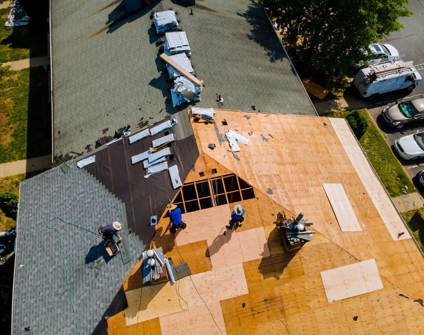 Roof replacement project with workers installing new shingles