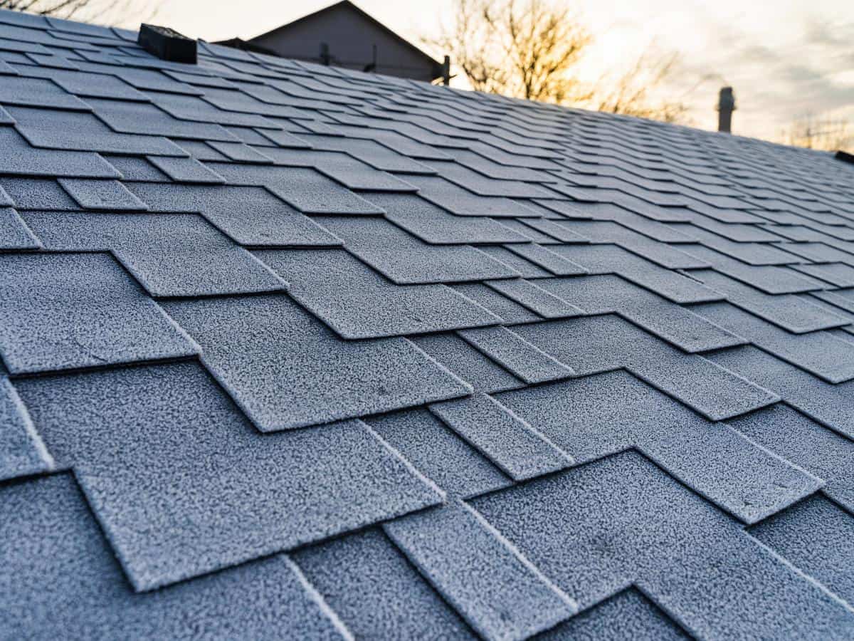 Close-up of asphalt shingle roof with sunset background in Monument, CO.