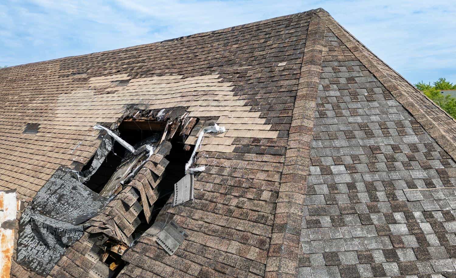 Damaged roof with missing shingles and exposed underlayment in Castle Rock, CO.