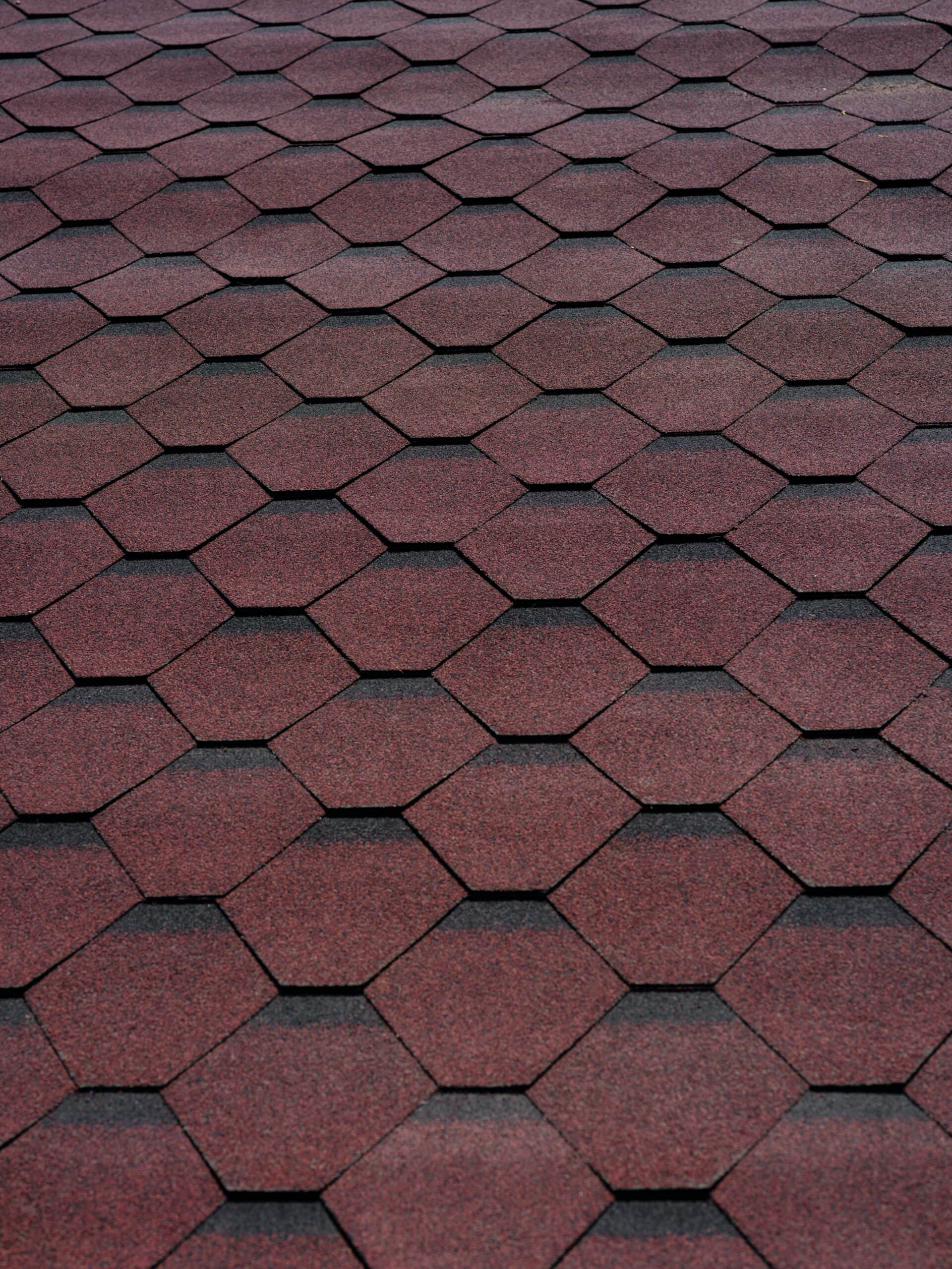 Close-up of red hexagonal roofing shingles for durability and style.